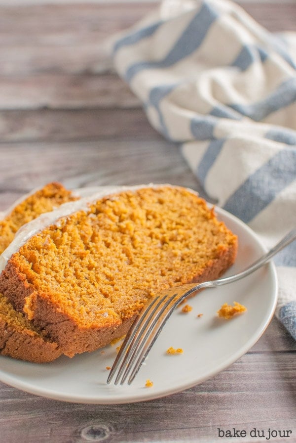 Pumpkin Bread with Cream Cheese Frosting - two slices of pumpkin bread on a white dish
