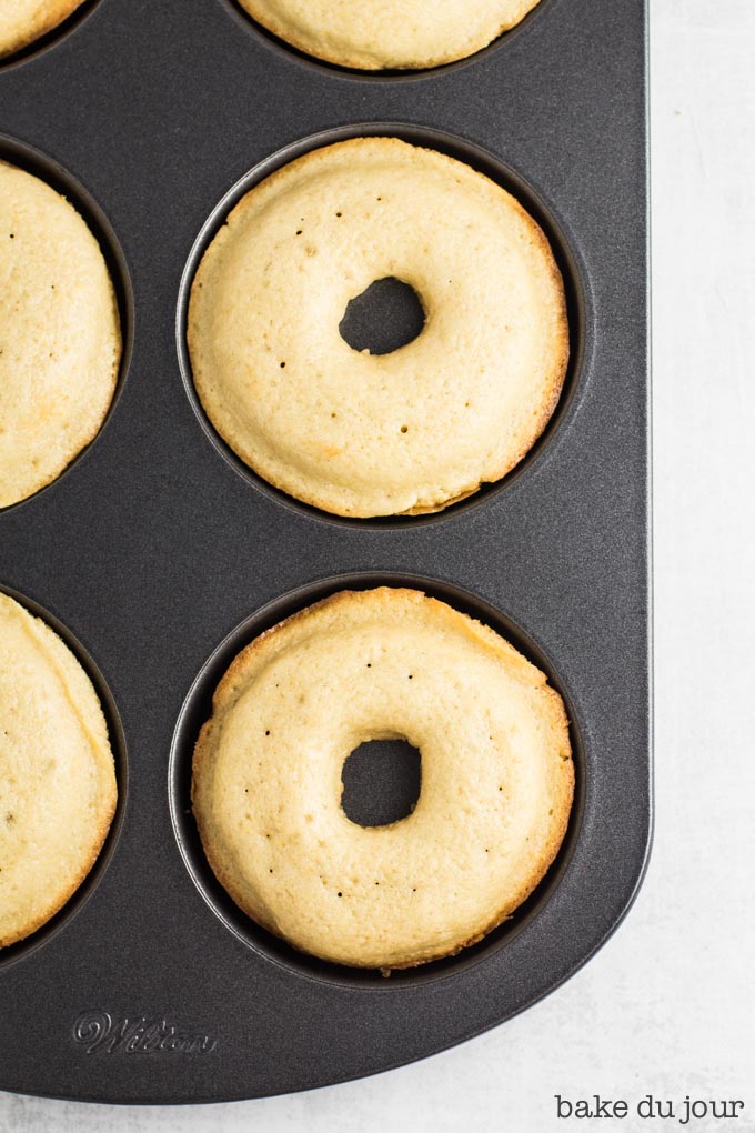 A shot of a few of the doughnuts in the pan after they came out of the oven 