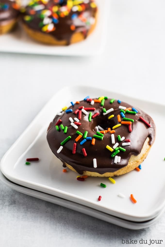 A Chocolate Frosted Doughnut on a square white dish